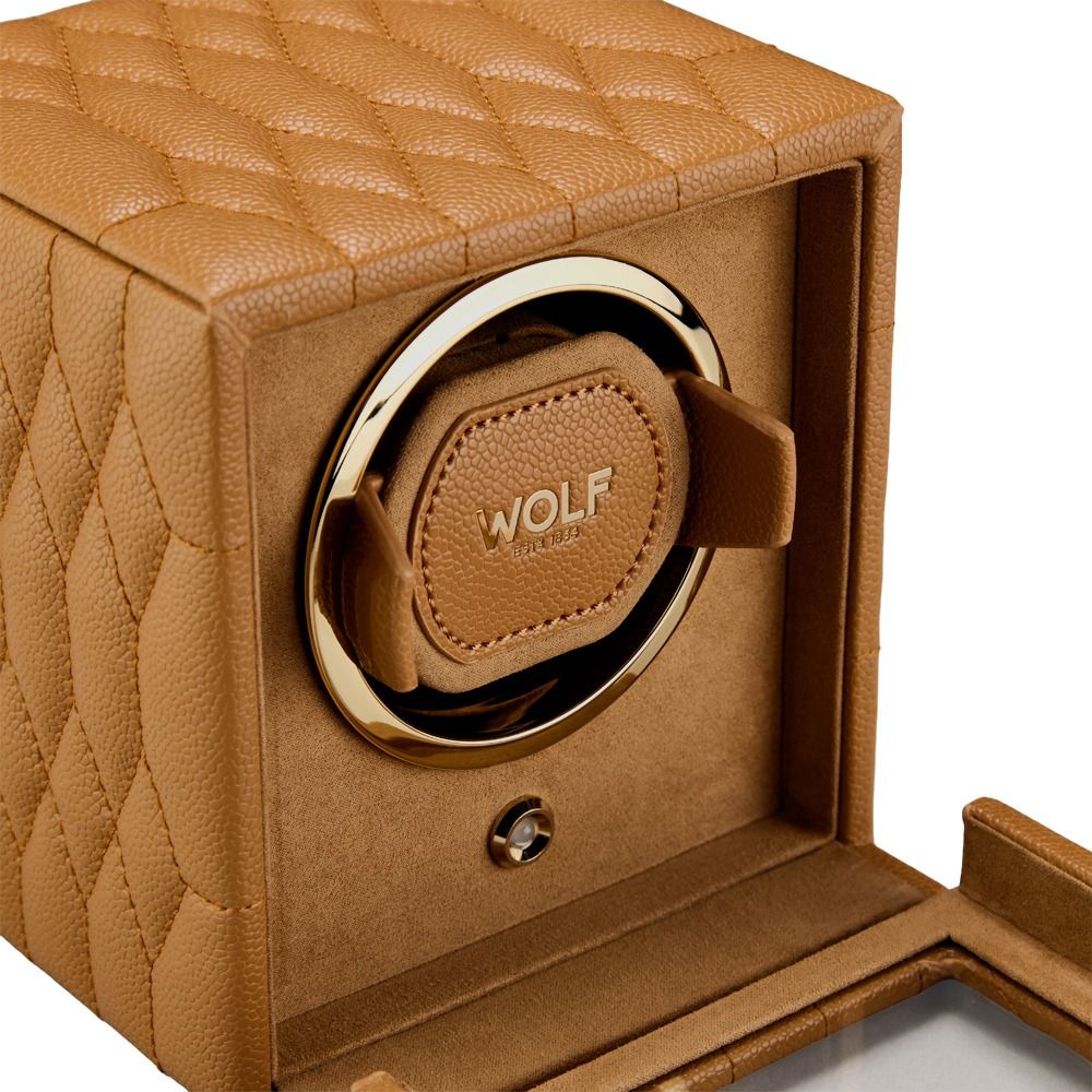The WOLF 1834 Lauren Single Watch Winder Carmel is a tan quilted leather watch winder by WOLF, featuring a gold trim, an open front cover, and a soft interior designed to securely hold and rotate your wristwatch. Inspired by classic British roadsters.