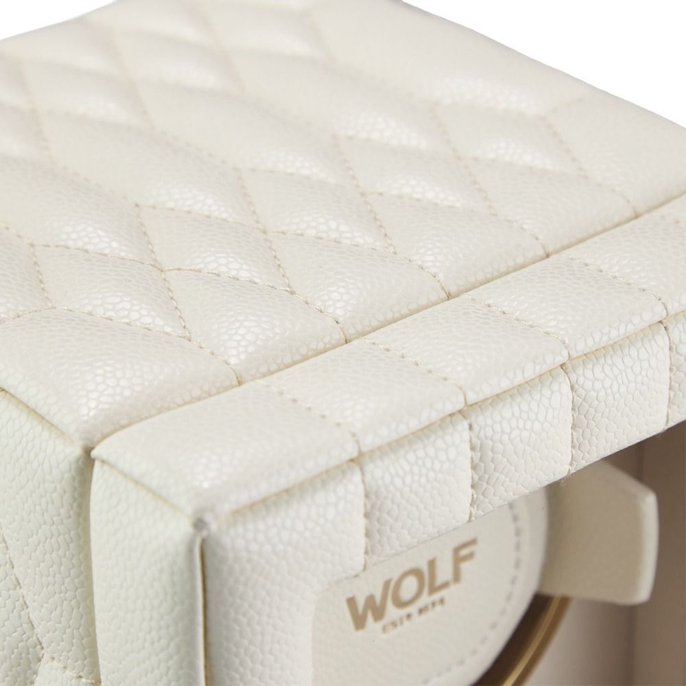 Close-up of the WOLF 1834 Lauren Single Watch Winder in ivory, featuring quilted cream-colored leather with visible stitching and sleek chrome hardware accents. The interior displays the brand name “WOLF” and “Est. 1834.”.