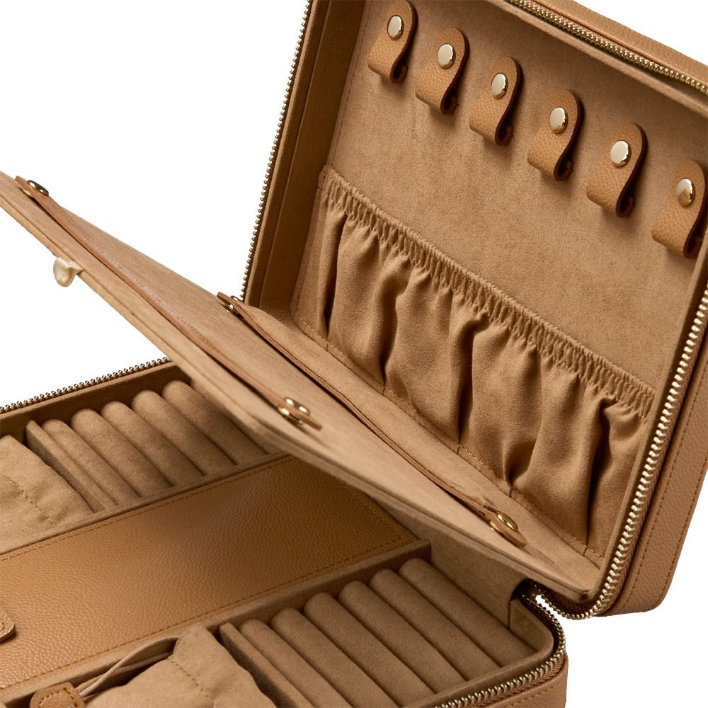 Discover the WOLF 1834 Lauren Large Zip Case Carmel by WOLF—this tan leather jewelry organizer features multiple ring rolls, elastic pockets, and secure snap closures for necklaces inside. Its interior is lined with a soft material to help protect your pieces, making this travel jewellery case perfect for keeping accessories organized and secure while on the go. The case is partially unzipped in the image, showcasing its thoughtfully designed compartments.