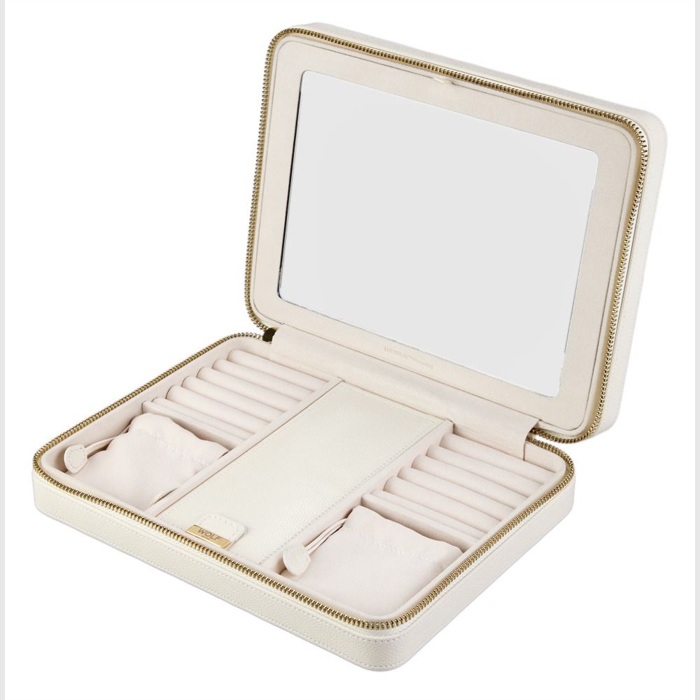 The WOLF 1834 Lauren Large Zip Case in ivory leather is shown unzipped, revealing ring slots, compartments, and a spacious mirror inside the lid.