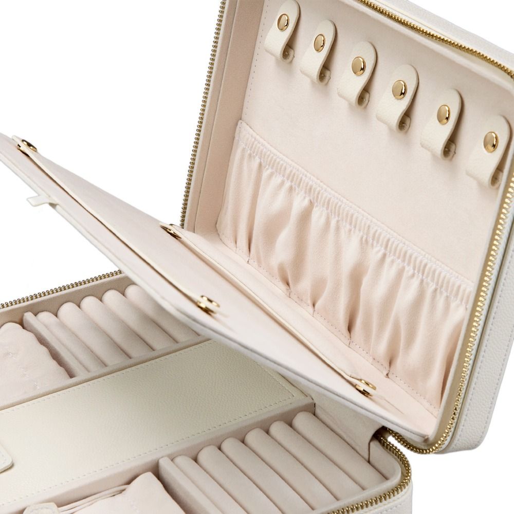 The WOLF 1834 Lauren Large Zip Case in Ivory is an open, cream-colored leather jewelry organizer featuring compartments, ring rolls, an elastic pouch, and hooks for necklaces or bracelets. Designed by WOLF as a travel jewellery case, this anti-tarnish jewelry box offers a zipper closure and a soft, padded interior.