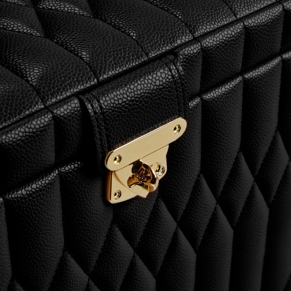Close-up of the WOLF 1834 Lauren Med Jewellery Box in black quilted leather with a gold latch. The textured pattern and detailed stitching create a luxurious and elegant look. This WOLF jewelry case features signature LusterLoc™ lining to help preserve your jewelry’s natural beauty.