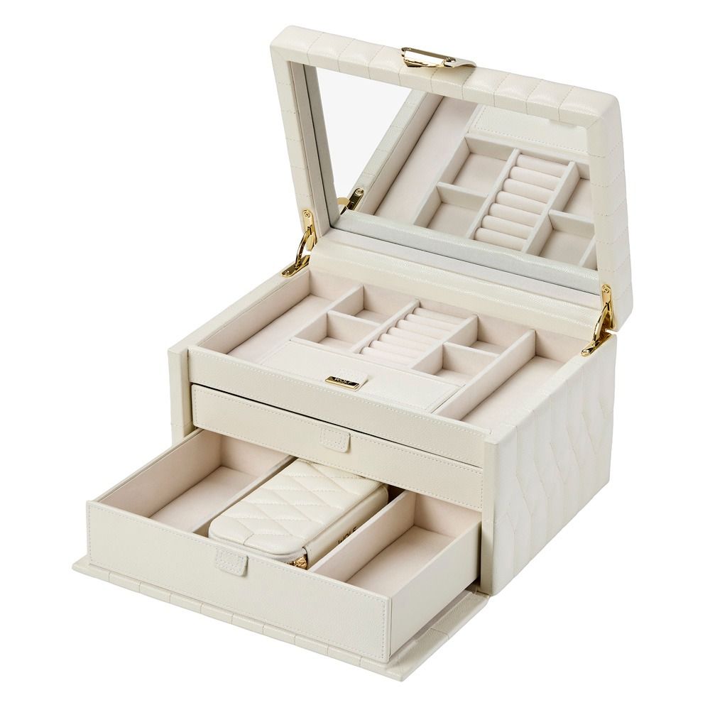 The WOLF 1834 Lauren Med Jewellery Box Ivory by WOLF is a cream-colored leather case featuring a mirror inside the lid, multiple compartments for rings and accessories, and a pull-out drawer. Its quilted pattern provides anti-tarnish protection, blending elegance and functionality to keep your jewelry beautifully organized and safe.