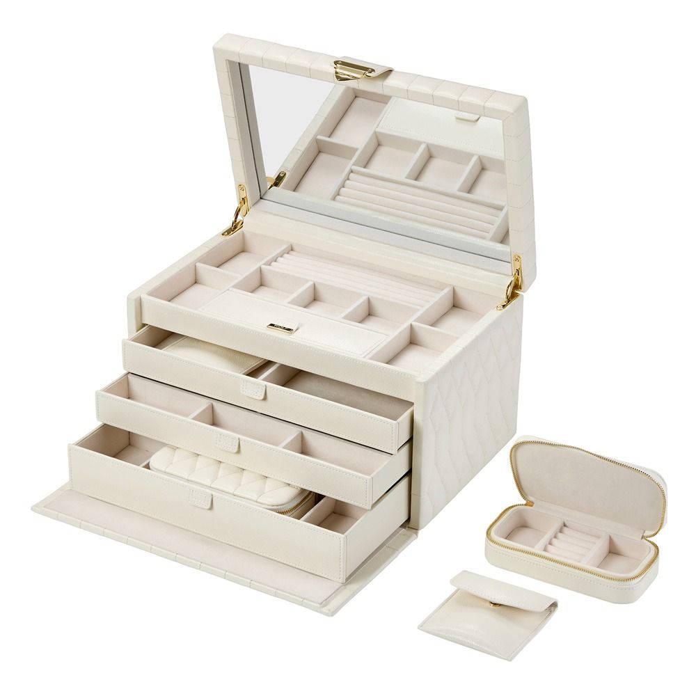 The WOLF 1834 Lauren Large Jewellery Box in Ivory features diamond-quilted leather in a cream hue, with an open lid displaying a mirror, ring slots, compartments, and two pull-out drawers for organized storage and tarnish prevention. Shown alongside are the matching travel jewellery case and pouch by WOLF.