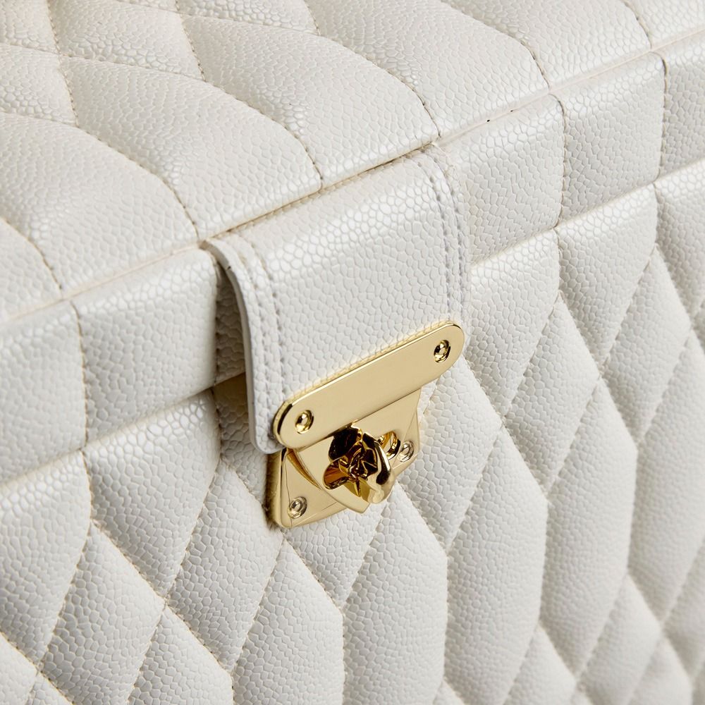 Close-up of the WOLF 1834 Lauren Large Jewellery Box in Ivory, crafted from white diamond-quilted leather with a gold clasp. The luxurious, textured surface features an elegant diamond pattern, while the secure lock enhances both sophistication and protection against tarnishing for your cherished jewellery pieces.