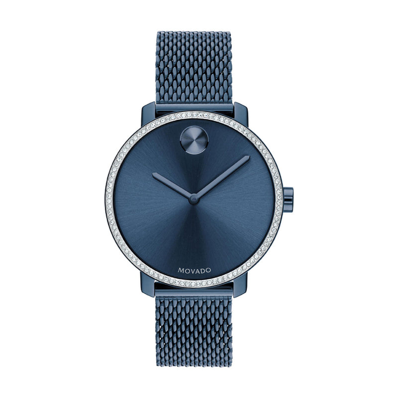 The Movado BOLD Shimmer Quartz 34mm Watch is a sleek timepiece featuring a blue ion-plated stainless steel mesh strap and a minimalist blue dial. The crystal pave bezel is adorned elegantly, with two simple hands and no numerals, complemented by a small silver dot at the 12 o'clock position.