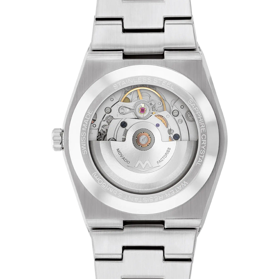 The Movado BOLD Quest Automatic 39mm Watch is a silver wristwatch with a black dual texture dial and transparent exhibition caseback, revealing its intricate mechanical components. It features a stainless steel bracelet and engraved details around the caseback, showcasing its self-winding movement.