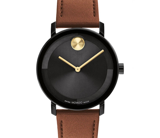 The Movado BOLD Evolution 2.0 Quartz 40mm Watch by Movado is a minimalist timepiece with a micro-textured tonal dial, gold hands, and a gold dot at 12 o'clock. It features a sleek black ion-plated stainless steel case complemented by a luxurious cognac leather strap.