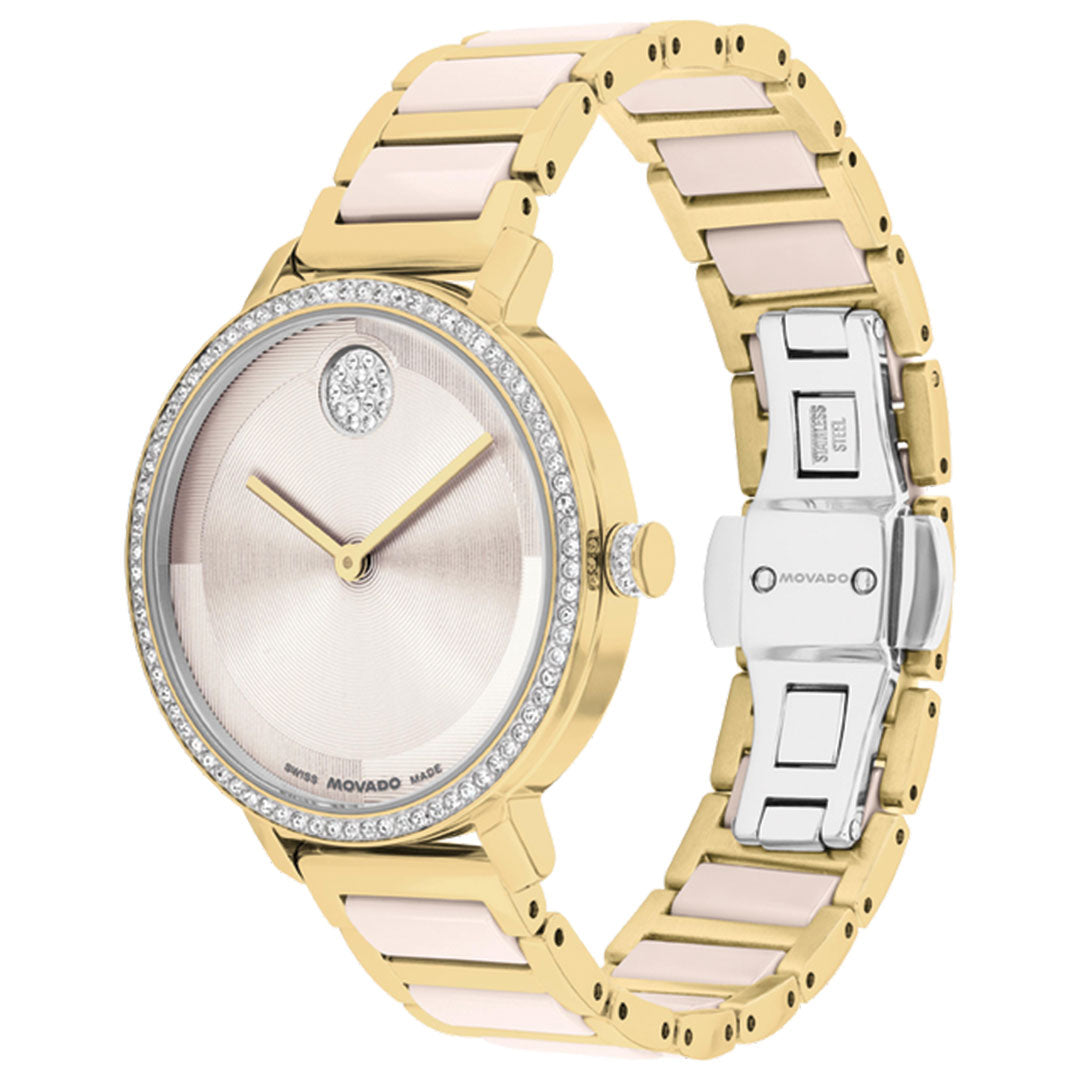 The Movado BOLD Evolution 2.0 Quartz 34mm Watch features a gold and silver metal band, a micro-textured round dial, diamond accents, a crystal-set bezel, and a signature crystal at 12 o'clock for refined elegance.