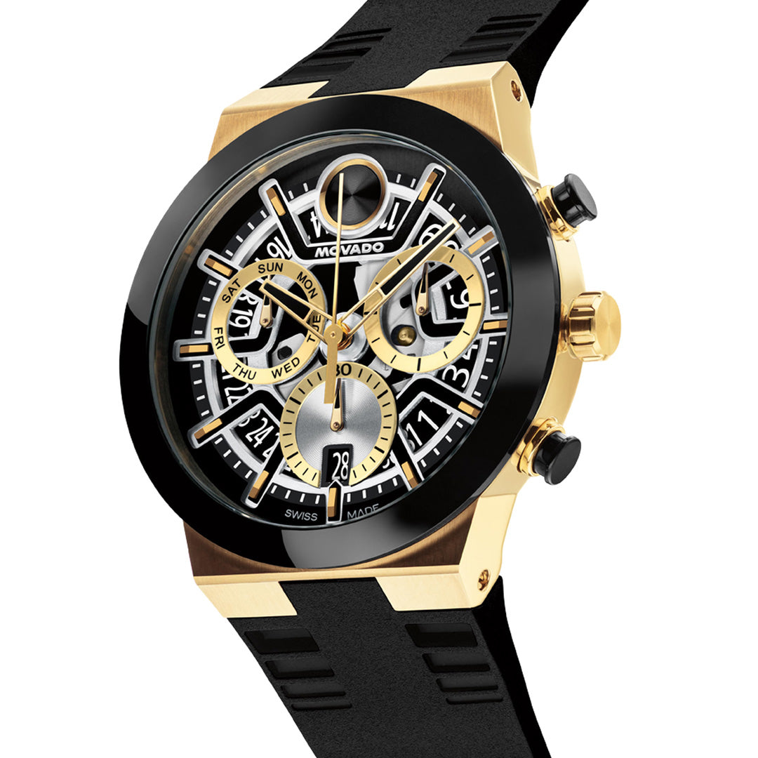 Movado BOLD Fusion Chronograph Quartz 44.5mm Watch by Movado, featuring a yellow gold ion-plated bezel, black rubber strap, three subdials for day, date, and 24-hour time display, and detailed gear-inspired accents on the dial reminiscent of a skeleton watch.