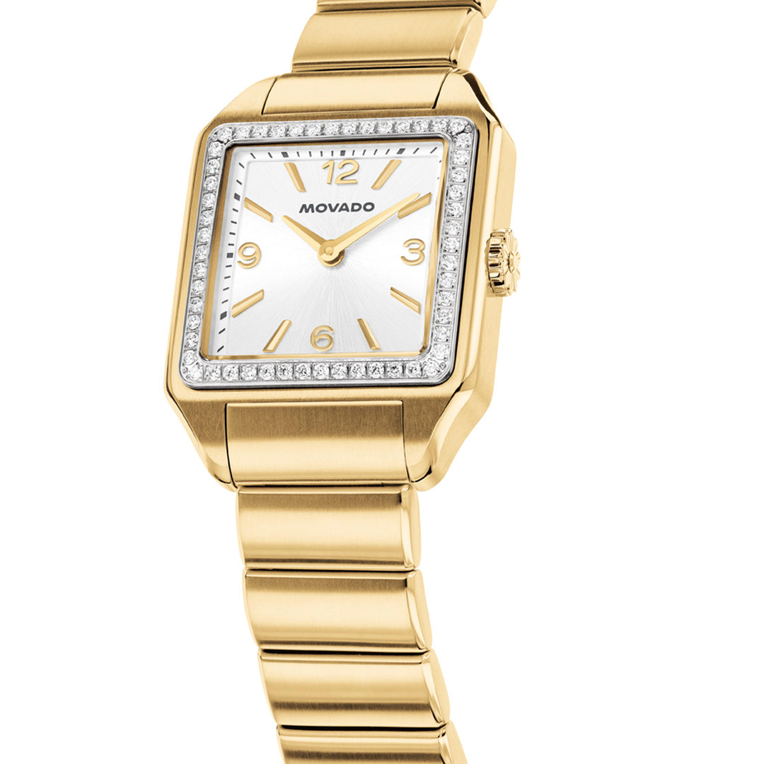 The Movado Heritage 1917 Quartz 25mm x 34.10mm watch features a refined square gold-tone case with a linked metal bracelet to match, showcasing Art Deco-inspired elegance. Its silver dial displays gold hour markers, while a sparkling lab-grown diamond bezel adds brilliance—drawing inspiration from Movado’s iconic Heritage 1917 collection.
