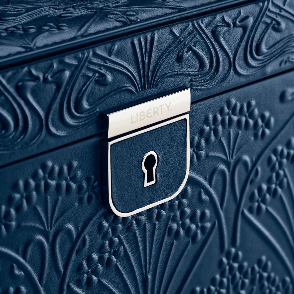 Close-up of the WOLF 1834 X Liberty All Over Ianthe Large Jewellery Box in Navy, featuring an embossed floral pattern and a centered silver lock plate engraved with “LIBERTY.” The interior includes tarnish prevention to keep your treasures pristine.