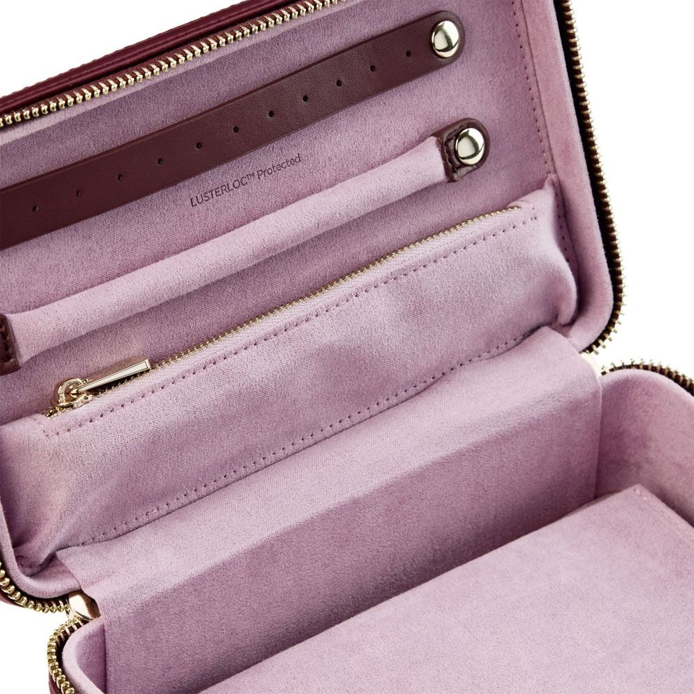 Keep your accessories safe and organized on the go with the WOLF 1834 X Liberty All Over Ianthe Medium Jewellery Zip Case in Burgundy. This travel jewelry case by WOLF features a zippered pocket, ring holder, and strap for securing your items. The soft interior is printed with “LUSTERLOC Protected,” making this anti-tarnish jewelry box ideal for stylish and secure storage wherever you travel.