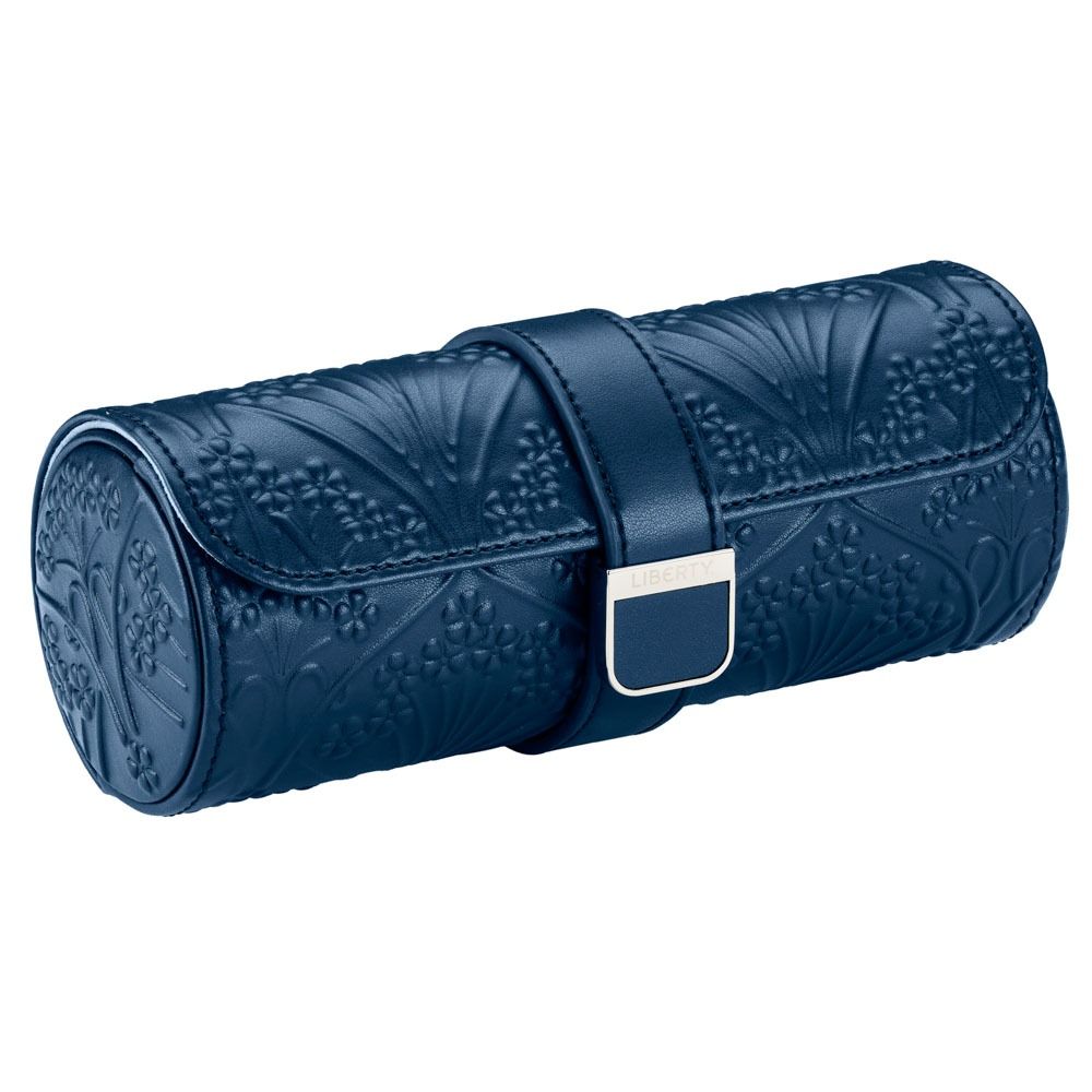 Introducing the WOLF 1834 X Liberty All Over Ianthe Triple Watch Roll Navy—a sleek cylindrical leather watch case in navy, featuring an embossed floral Ianthe pattern and secured with a strap and silver buckle, making it the ideal stylish travel storage solution for your watches.