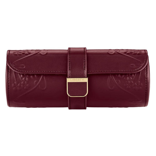 A burgundy leather watch roll from WOLF, crafted in collaboration with Liberty, showcases embossed Ianthe floral patterns and features a secure flap closure with a gold clasp engraved “Liberty.” Inside, find thoughtfully designed compartments for your treasured timepieces—seamlessly combining refined elegance with functional sophistication.