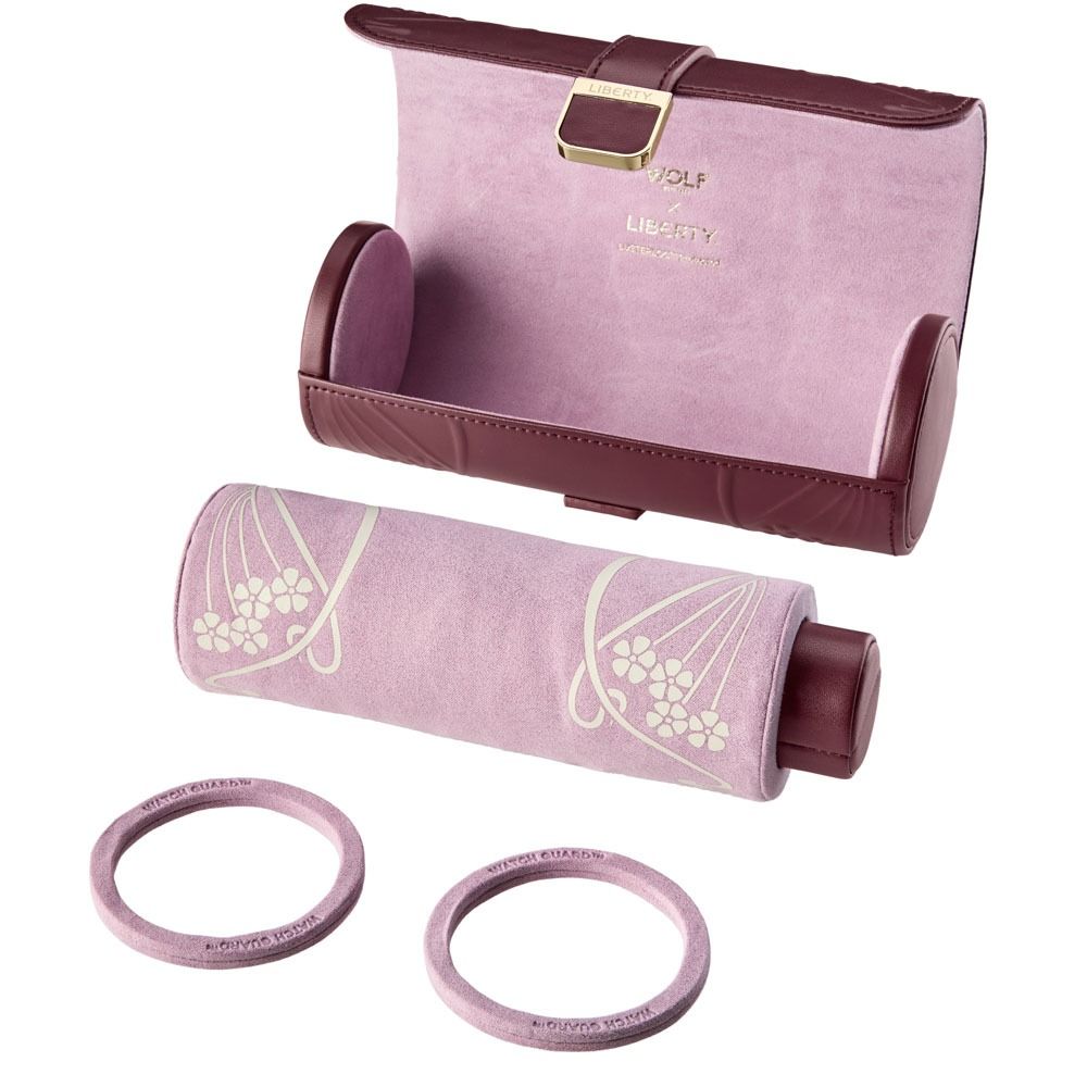 A burgundy jewelry travel case from WOLF featuring the WOLF 1834 X Liberty All Over Ianthe floral pattern, paired with a matching cylindrical leather Triple Watch Roll and two bangle holders.