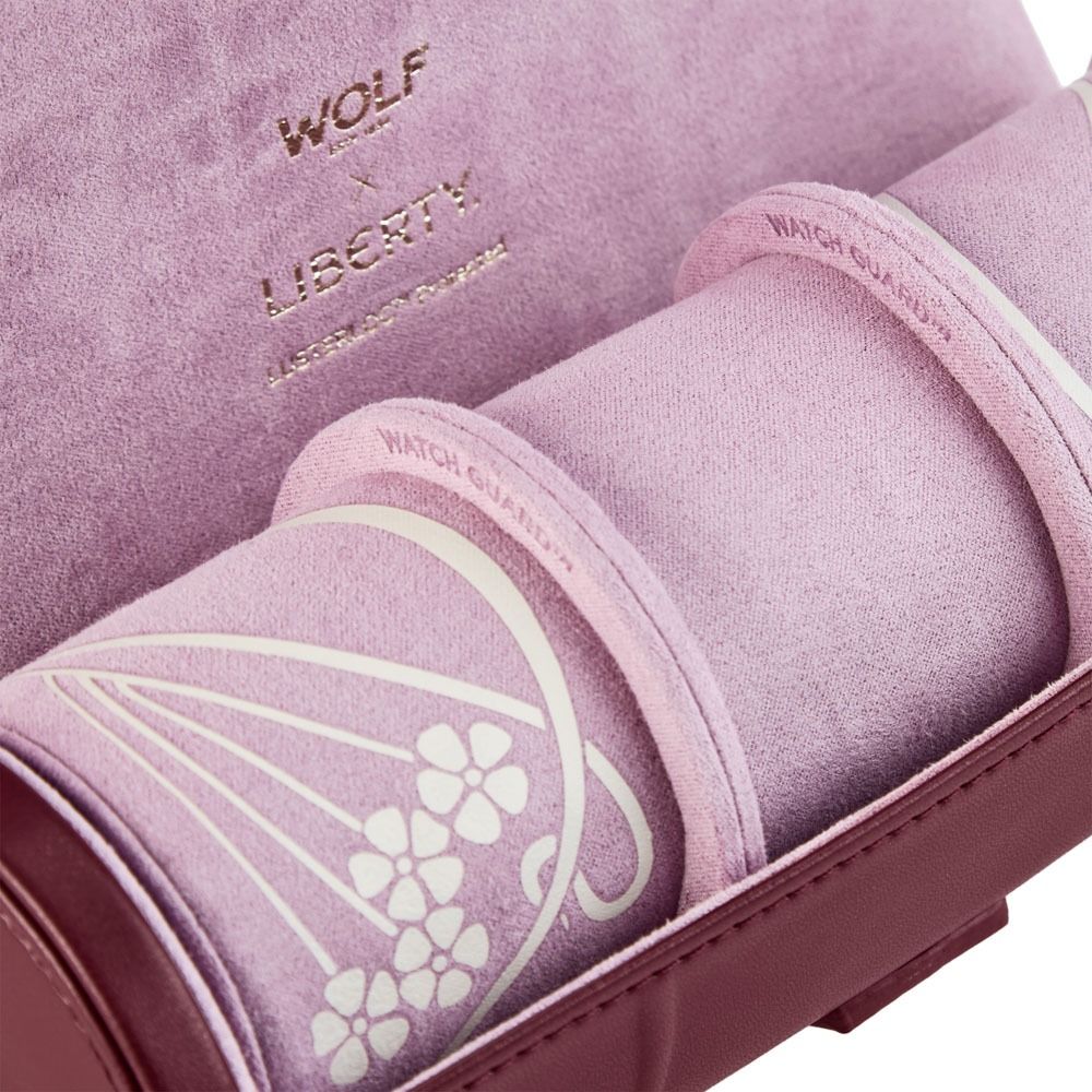 Close-up of the WOLF 1834 X Liberty All Over Ianthe Triple Watch Roll in burgundy suede leather, featuring intricate floral detailing and gold-embossed “WOLF x Liberty” and “London England” lettering on the inside lid. This elegant triple watch roll is perfect for keeping your timepieces secure and stylish while traveling.