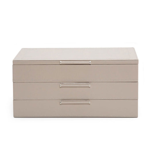 Introducing the WOLF 1834 Jewellery Box with Drawers, a rectangular, beige organizer crafted by WOLF from sustainable leather. It features three drawers adorned with sleek metal handles and LusterLoc anti-tarnish lining. This box offers a smooth texture and minimalist design, providing an elegant solution for jewelry storage.
