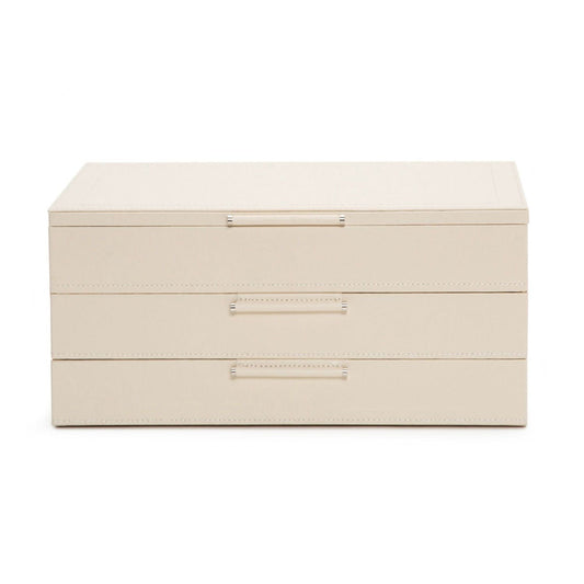 The WOLF 1834 Jewellery Box with Drawers by WOLF is a beige, rectangular piece featuring three stacked compartments, each adorned with a sleek horizontal metal handle. Made from sustainable leather, it showcases a minimalist design and includes an anti-tarnish lining, all set against a plain white background.