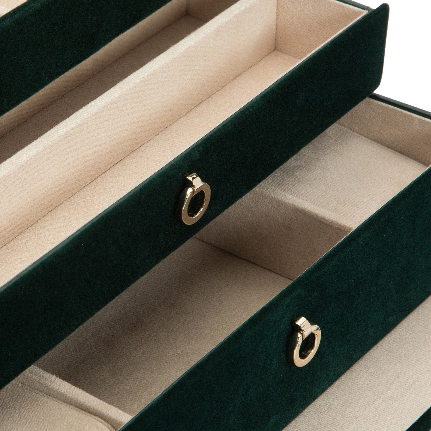 A detailed view of the WOLF 1834 Zoe Medium Jewellery Box reveals a lavish, open design with dual compartments lined in soft beige fabric. The exterior boasts a sumptuous dark green velvet finish equipped with WOLF's LusterLoc™ technology to prevent tarnishing. Each compartment is thoughtfully designed with a gold-toned pull, reflecting an elegant touch in jewelry storage by the renowned brand, WOLF.