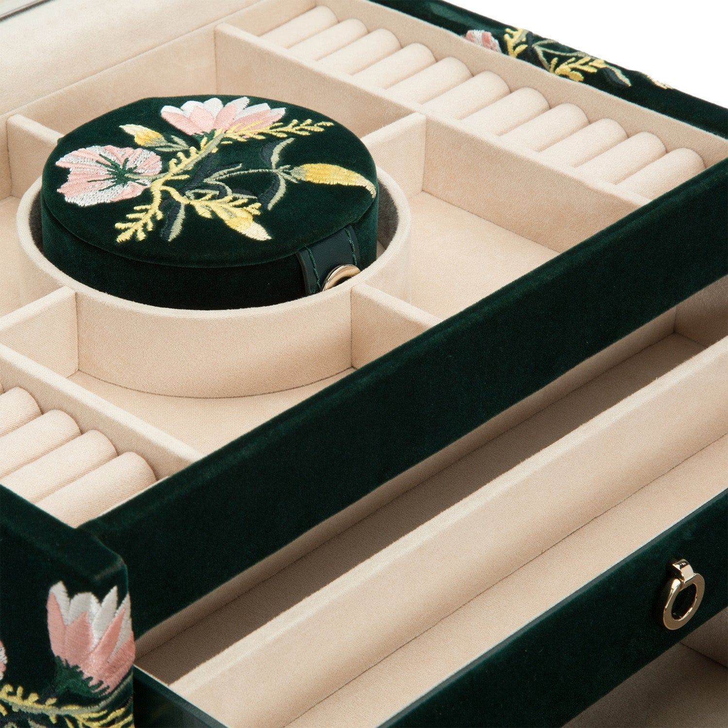 A close-up of the WOLF 1834 Zoe Medium Jewellery Box, lined with velvet and designed with compartments for rings and accessories. Created by WOLF, it incorporates tarnish prevention features and showcases elegant floral embroidery in pink and yellow on a green background for an organized design.