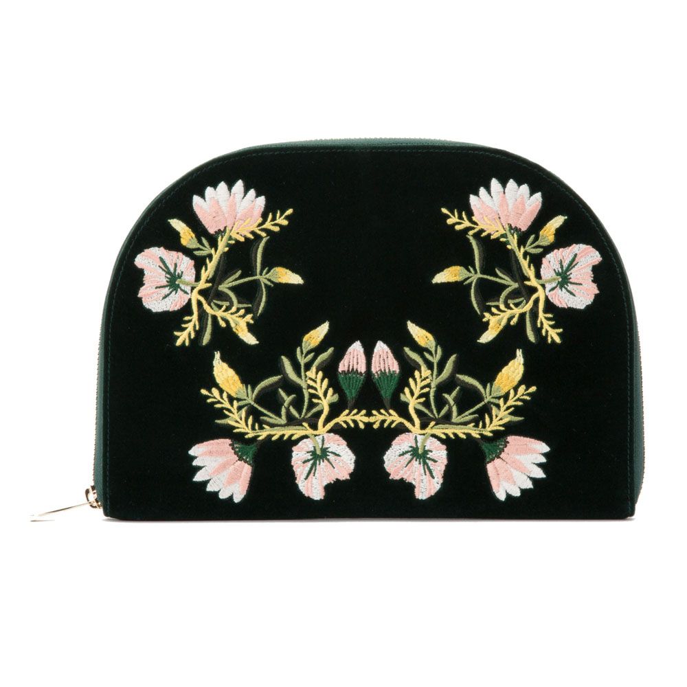The WOLF 1834 Zioe Jewellery Portfolio by WOLF is a black velvet travel case with a zip closure, accented with symmetrical embroidered floral patterns in pink, yellow, and green.