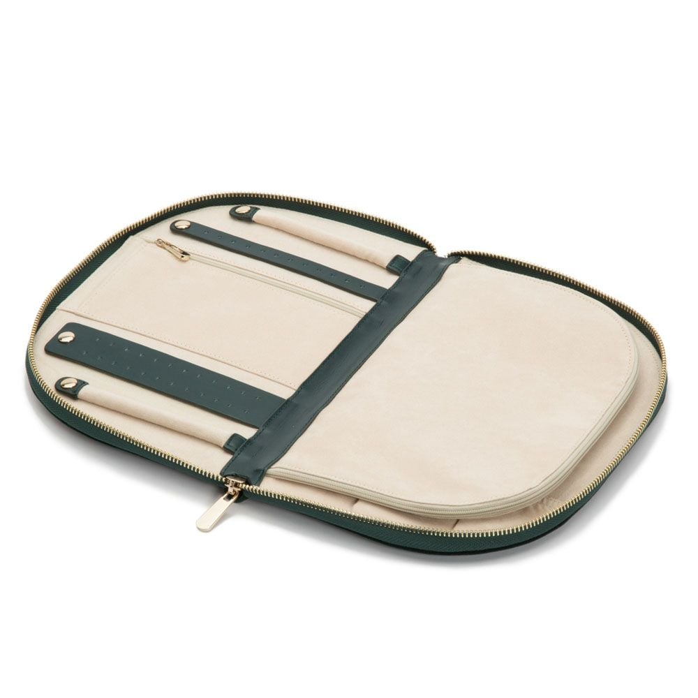 The WOLF 1834 Zioe Jewellery Portfolio by WOLF is an open beige and dark green travel case with organized slots, LusterLoc lining, and compartments holding two pens and a ruler, displayed on a white background.