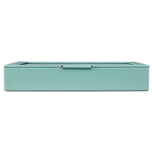 The WOLF 1834 X Fiona Howard Botanical Jewellery Box With Window by WOLF is a rectangular, light blue travel jewelry case with white stitching and a glass lid, shown closed from the front. This elegant jewelry box features an anti-tarnish lining to help keep your pieces looking their best.
