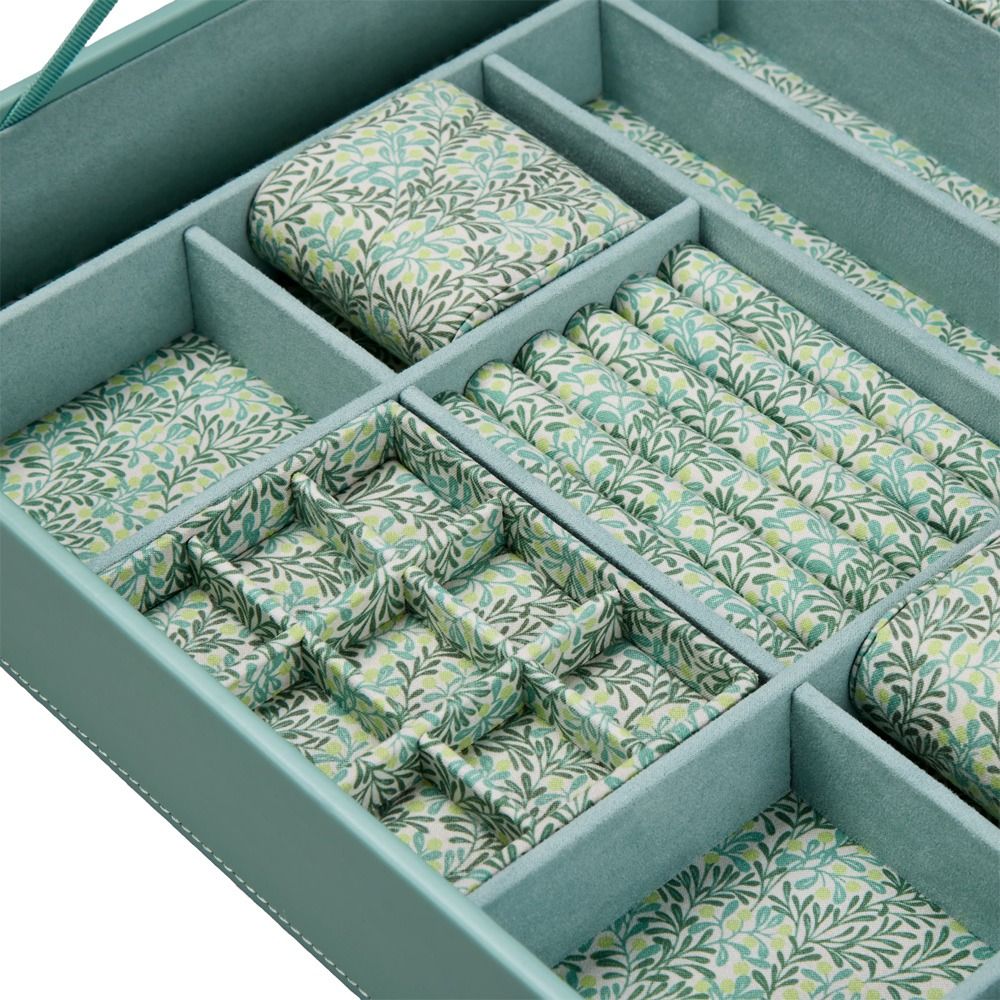 The WOLF 1834 X Fiona Howard Botanical Jewellery Box With Window by WOLF features a matching green exterior and interior, with multiple compartments lined in soft anti-tarnish fabric to keep your jewelry protected. Each compartment beautifully organizes your pieces, while the leafy patterned fabric in shades of green, blue, and yellow adds a botanical touch.