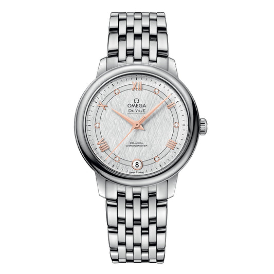 The OMEGA De Ville Prestige Co-Axial Chronometer 32.7mm Watch, featuring a silver tone with a stainless steel bracelet, showcases rose gold hour markers on its face, along with a date display at the 6 o'clock position. It is elegantly detailed with the Omega logo and "Co-Axial Chronometer Calibre 2500" text.