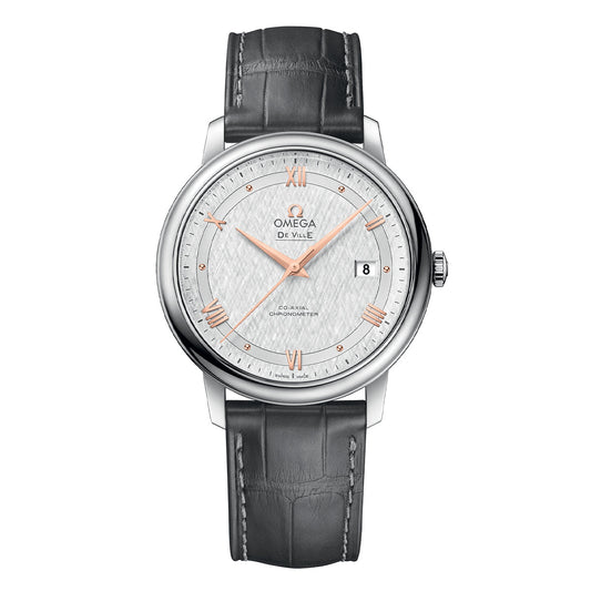 The OMEGA De Ville Prestige Co-Axial Chronometer 39.5mm Watch, from the renowned brand OMEGA, features a textured white silk-pattern dial adorned with rose gold Roman numerals. It includes a date window at 3 o'clock and is elegantly set in a sleek silver case with a grey leather strap.