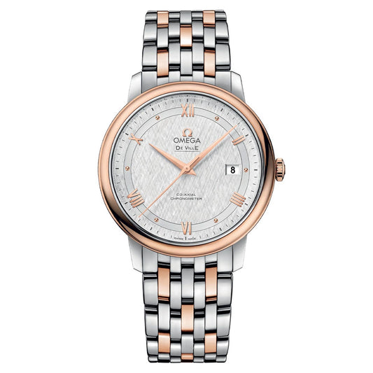Indulge in the luxury of the OMEGA De Ville Prestige Co-Axial Chronometer 39.5mm Watch, featuring a sophisticated silver and rose gold metal band. This exquisite timepiece boasts a white silk-patterned dial adorned with rose gold Roman numerals and hands, along with the prestigious OMEGA Co-Axial Chronometer certification and a date display at 3 o'clock.