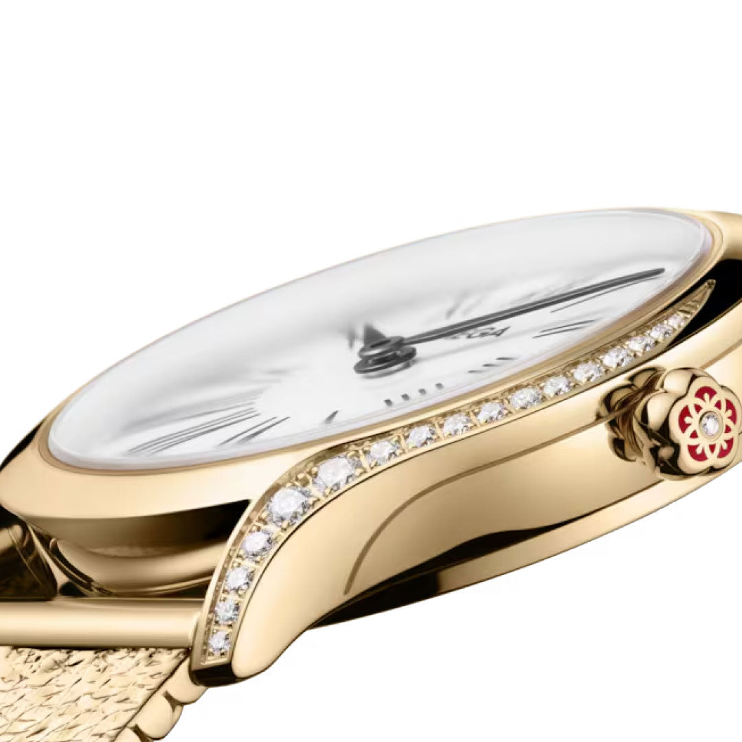 A close-up side view of the OMEGA De Ville Mini Tresor Quartz 26mm watch, featuring a diamond-studded bezel, Roman numeral markers, and a floral motif crown, set against a white background.