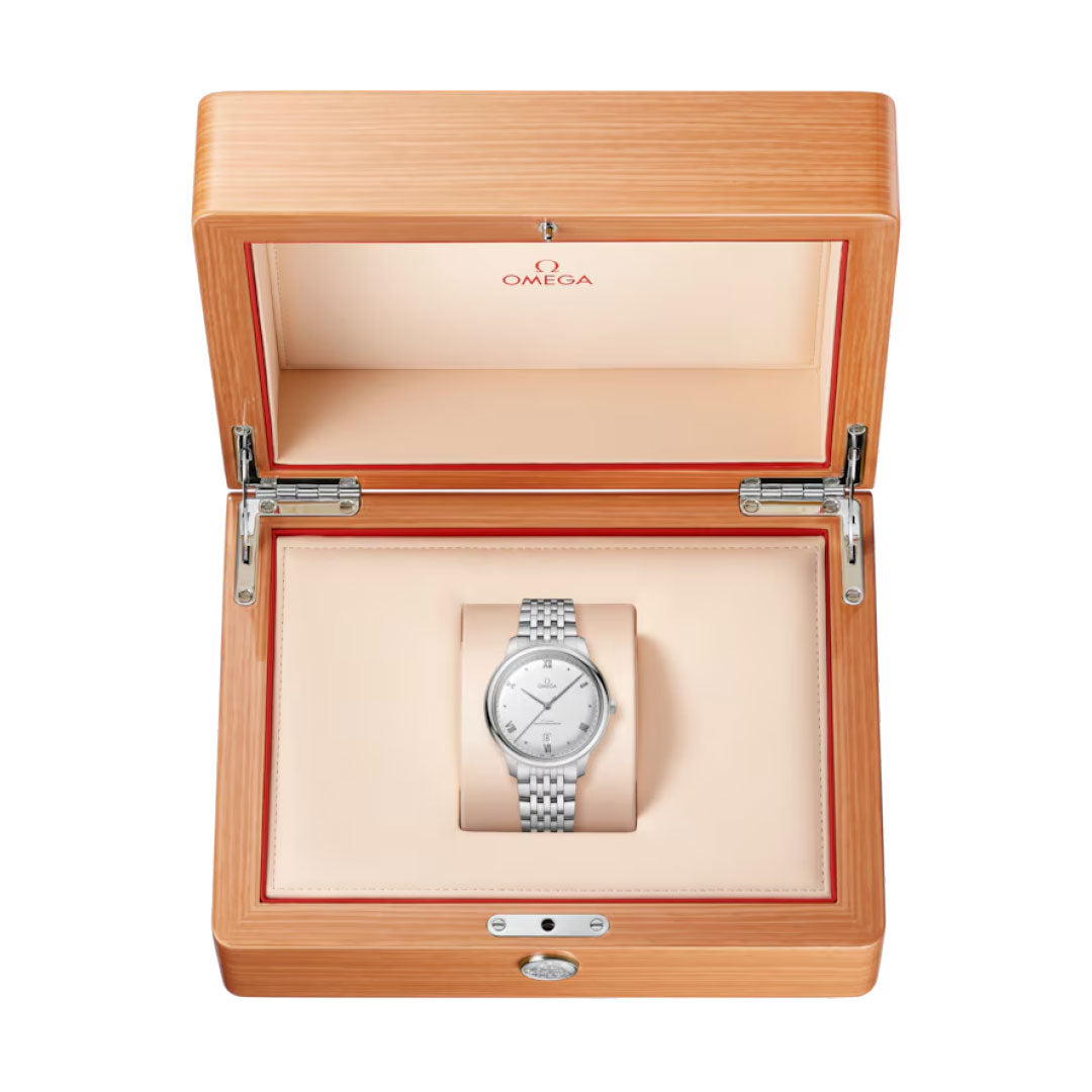 An OMEGA De Ville Prestige Co-Axial Master Chronometer 40mm Watch is presented in an open light wood box with cream interior padding and the OMEGA logo on the inside lid.