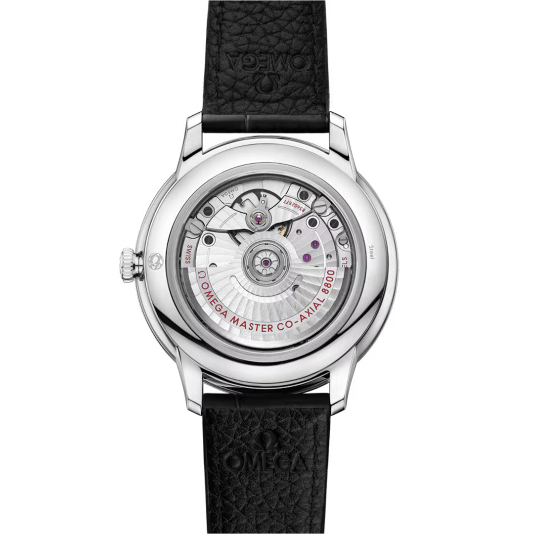 The back of the OMEGA De Ville Prestige Co-Axial Master Chronometer 40mm reveals its intricate movement with "Omega Master Co-Axial 8800" printed. A black leather strap embossed with the OMEGA logo complements the stainless steel case.