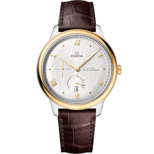 The OMEGA De Ville Prestige Co-Axial Master Chronometer 41mm features a silver dial, 18K yellow gold bezel, Roman numerals, date at 6 o'clock, and brown leather strap. Gold-toned hands and markers complete this luxury OMEGA watch.