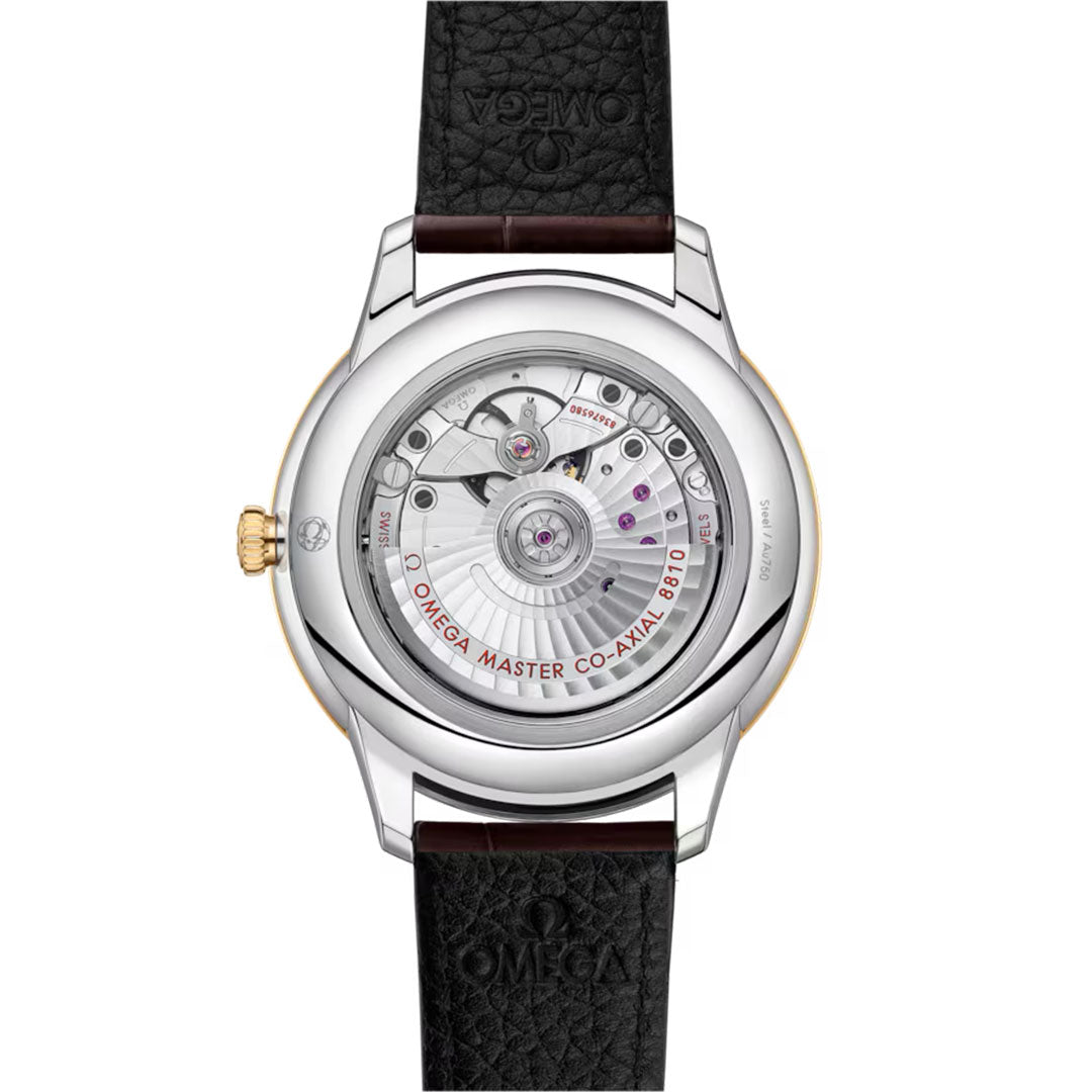 The back view of the OMEGA De Ville Prestige Co-Axial Master Chronometer 41mm Watch reveals a transparent case back, 18K yellow gold build, black textured leather strap, and mechanical movement with detailed engravings.