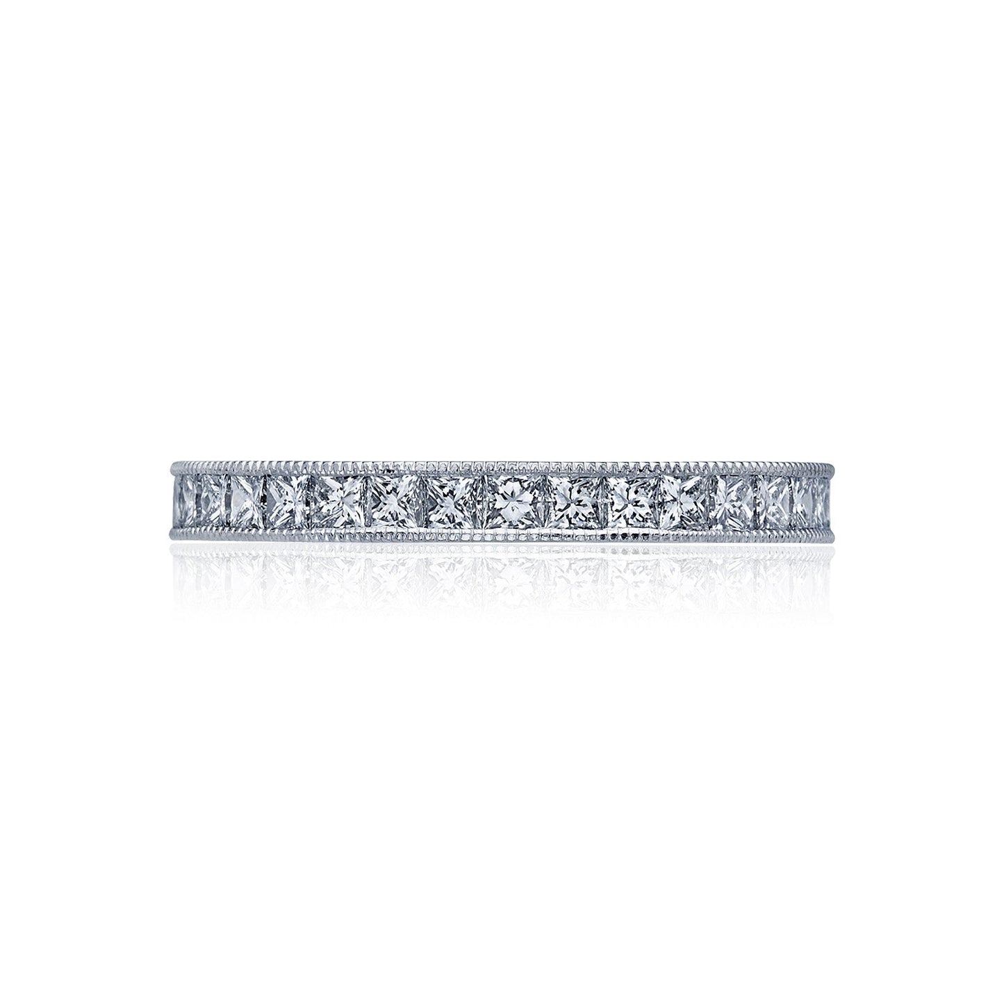 The Tacori Sculpted Crescent 18K White Gold Channel Set Round Brilliant Diamond Anniversary Ring features a row of small, sparkling diamonds set into the band. With its G color and VS clarity, along with intricate detailing along the edges, this exquisite piece exudes elegance and refinement. The ring is beautifully showcased against a plain white background.