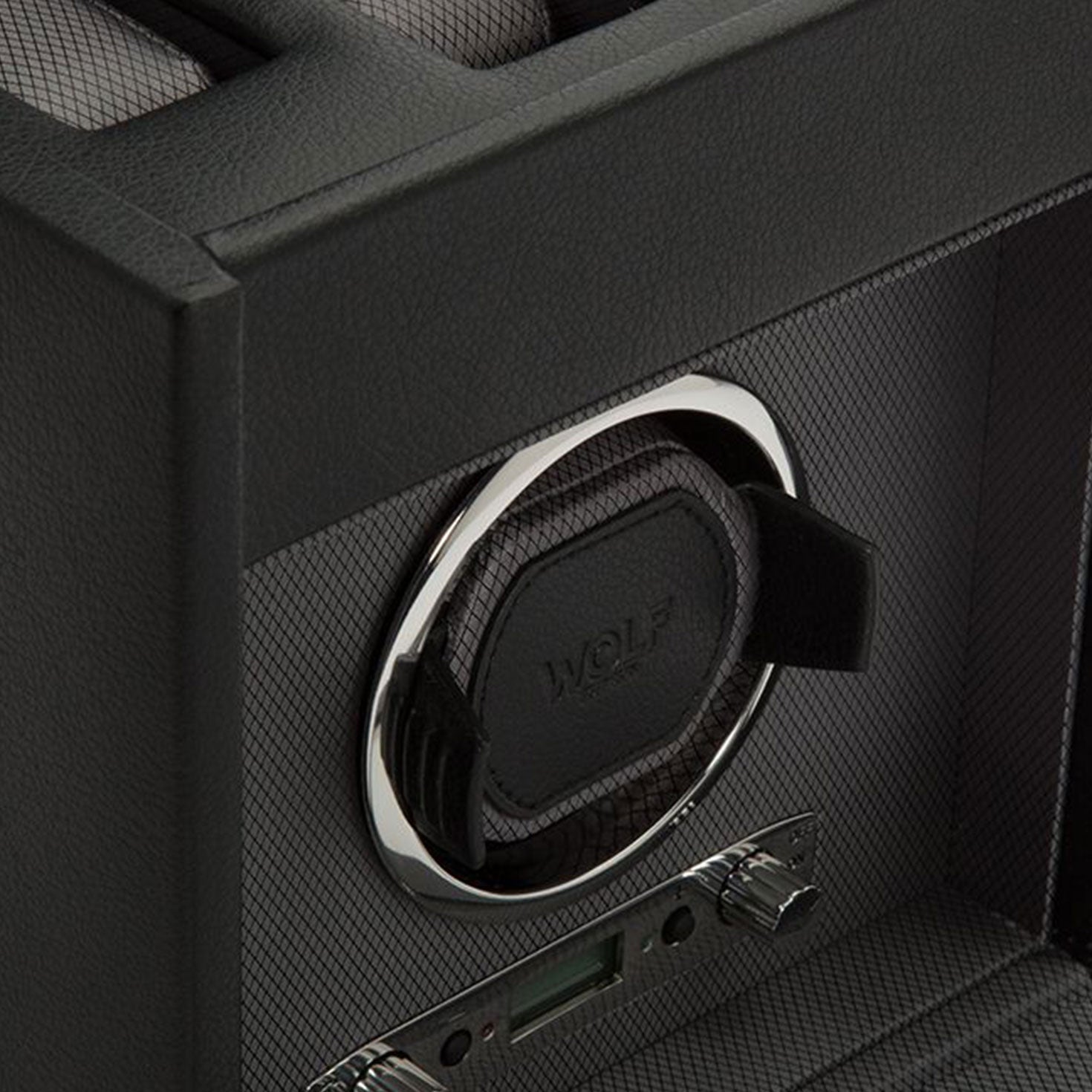 Close-up of a dark-colored WOLF 1834 Viceroy Single Winder with Storage, showcasing its circular holder and textured surfaces. This elegant accessory, from the renowned brand WOLF, features control knobs at the bottom to add a touch of sophistication to any collection.