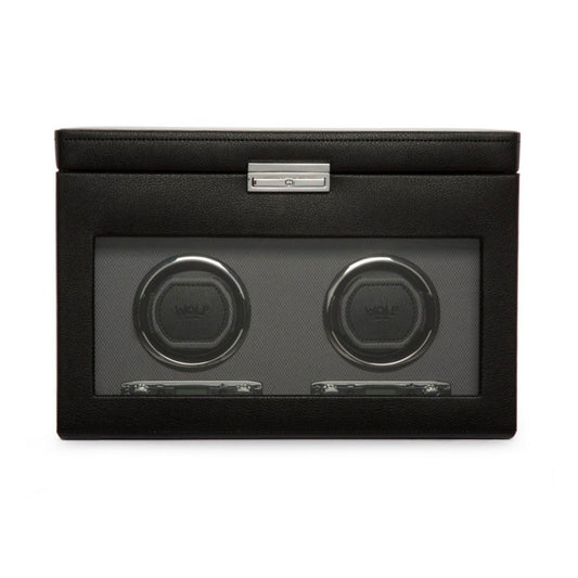 Introducing the WOLF 1834 Viceroy Black Watch Winder, a sophisticated accessory crafted by skilled designers. This exquisite piece boasts a sleek leather finish and a transparent display case that elegantly showcases two circular compartments. Made from high-quality materials, this watch winder is adorned with the esteemed brand name "Wolf" and includes a secure metal latch at the top for added elegance.
