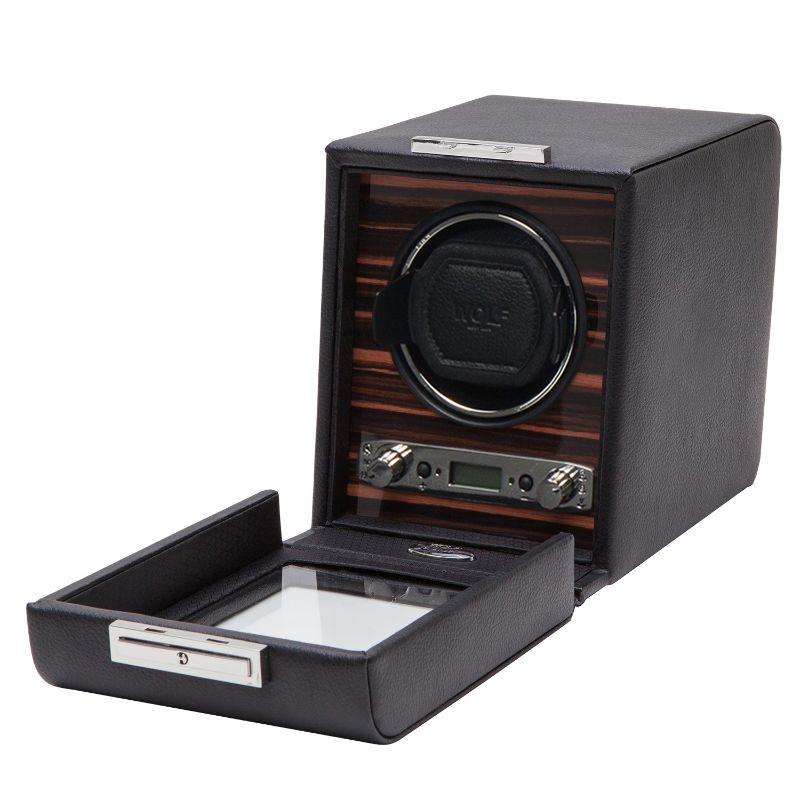The WOLF 1834 Roadster Single Winder, in black, exudes the elegance of British motorcars with its wooden interior and transparent front drawer. It features control knobs, a digital display on the front panel, and proudly bears the brand name "WOLF.