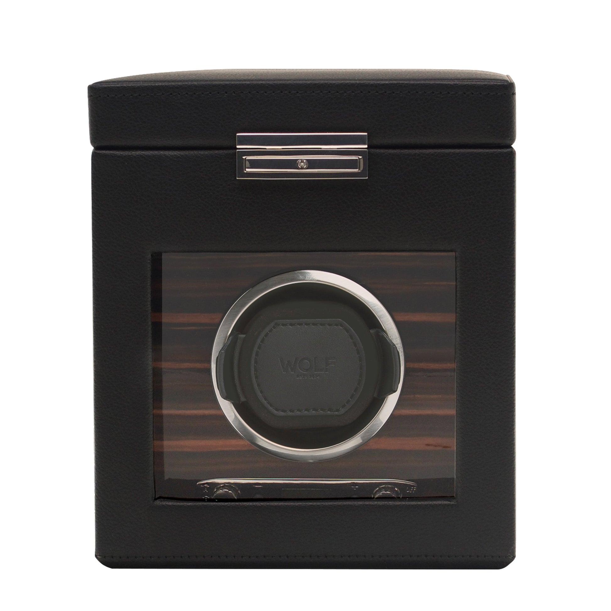The WOLF 1834 Roadster Single Watch Winder With Storage is a chic black accessory featuring a transparent window that reveals its interior. It flaunts a vegan leather texture and metal accents, with a single circular slot designed for one watch. The brand name "WOLF" is prominently displayed inside, highlighting its patented design innovation.