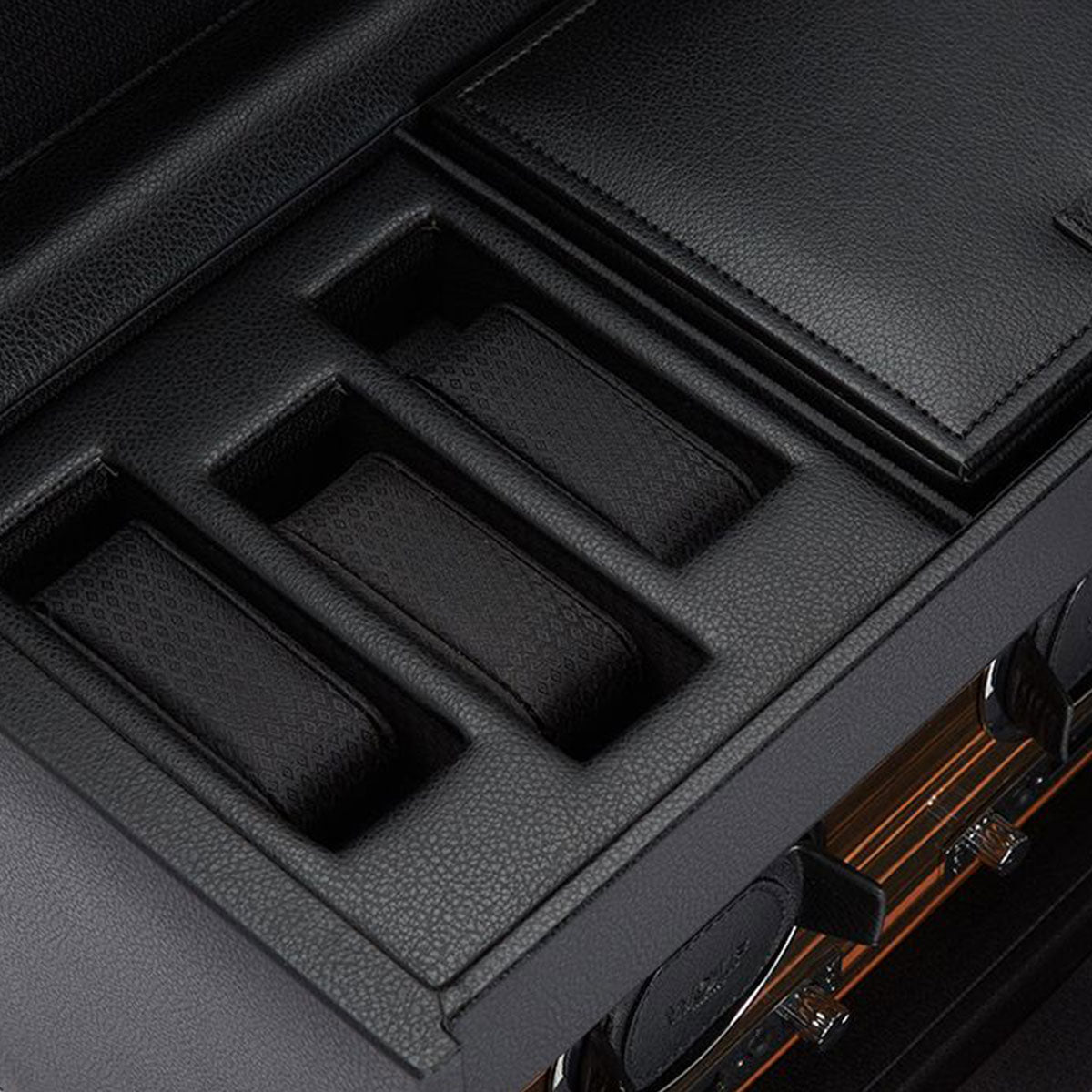 A detailed view of the WOLF 1834 Roadster Double Watch Winder With Storage by WOLF, showcasing its refined black leather finish inspired by the grace of British motorcars. The case features an upper section with slots for watch cushions and a lower section with a glass door that beautifully displays fine timepieces. Its meticulous organization exudes sophistication.