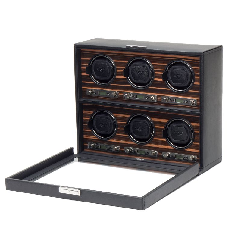 A WOLF 1834 Roadster 6 Piece Winder showcases an ebony macassar wooden design with an open glass door, revealing six elegantly arranged round compartments. These compartments contain watch winders from the WOLF brand, positioned in two rows and featuring a bi-directional setting for optimal convenience and style.