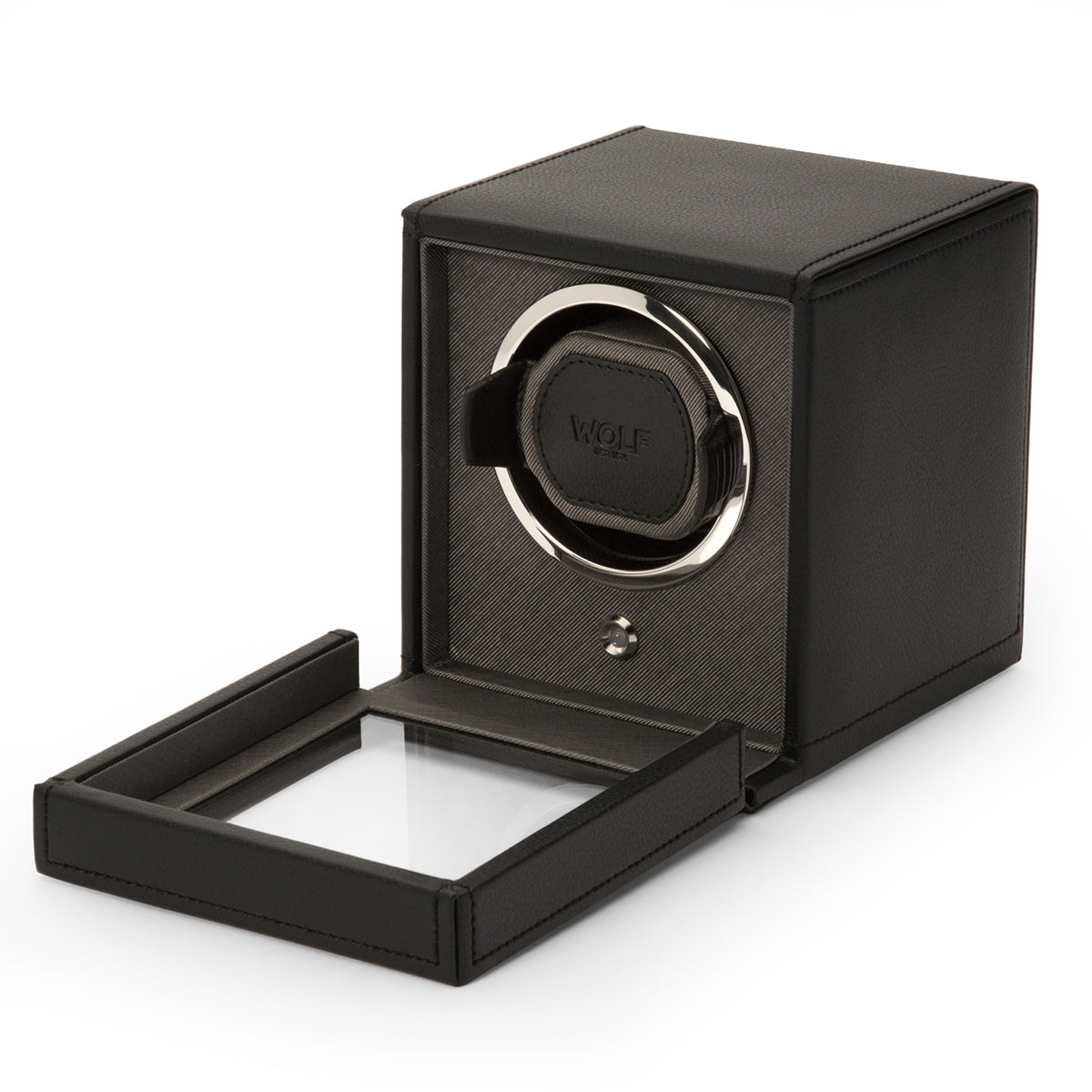 The WOLF 1834 Cub Winder With Cover is displayed, showcasing a soft, vegan leather finish in black and a transparent cover. The brand name "WOLF" is prominently visible on the inner mechanism. This bi-directional device is engineered to keep automatic watches wound and ready to wear.
