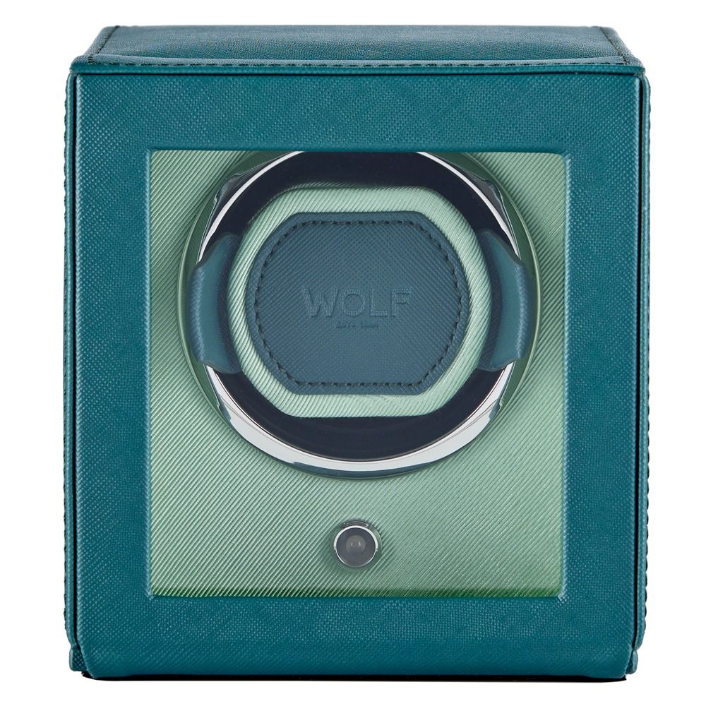 The WOLF 1834 Cub Single Watch Winder Teal by WOLF features a striking teal vegan leather exterior and a glass front display, showcasing a circular holder inside with a button positioned below the window. This elegant watch winder also incorporates WOLF’s patented rotation programs to ensure your timepiece remains perfectly wound.