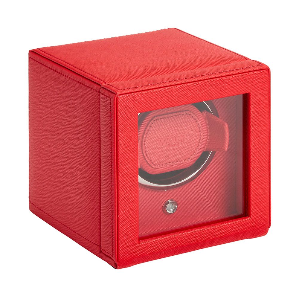 The WOLF 1834 Cub Single Watch Winder Red by WOLF is a cube-shaped, vegan leather winder with a clear front panel, single watch holder, sleek modern design, rotation programs for optimal care, and a small silver front button.