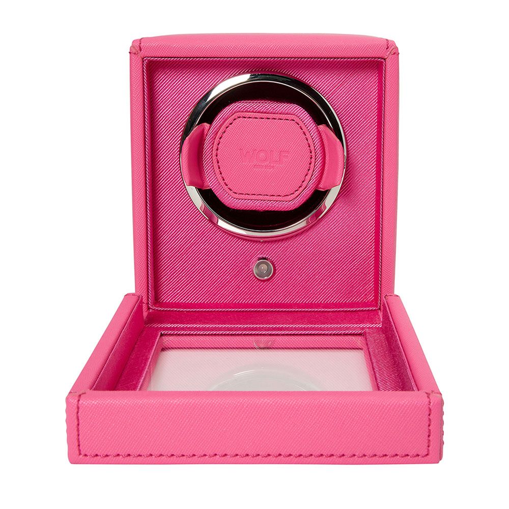 The WOLF 1834 Cub Single Watch Winder in bright pink vegan leather features an open lid, showcasing its round watch compartment, patented lock-in dynamic cuff, and the WOLF brand logo inside.
