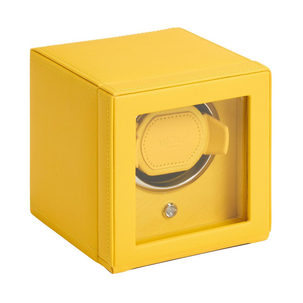 The WOLF 1834 Cub Single Watch Winder in yellow features a cube shape, glass front panel, circular watch holder, and vegan leather with clean stitching for a modern, elegant look.