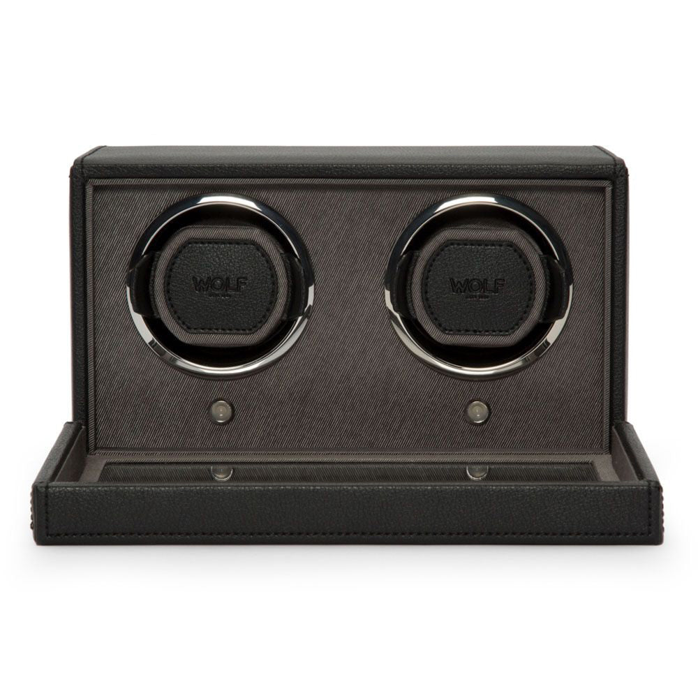 The WOLF 1834 Cub Double Watch Winder With Cover is encased in a sleek vegan leather design, featuring two watch holders with the "WOLF" branding clearly visible inside. The open case highlights its elegant design, patented lock-in cuff, and functionality, making it perfect for storing and winding watches.